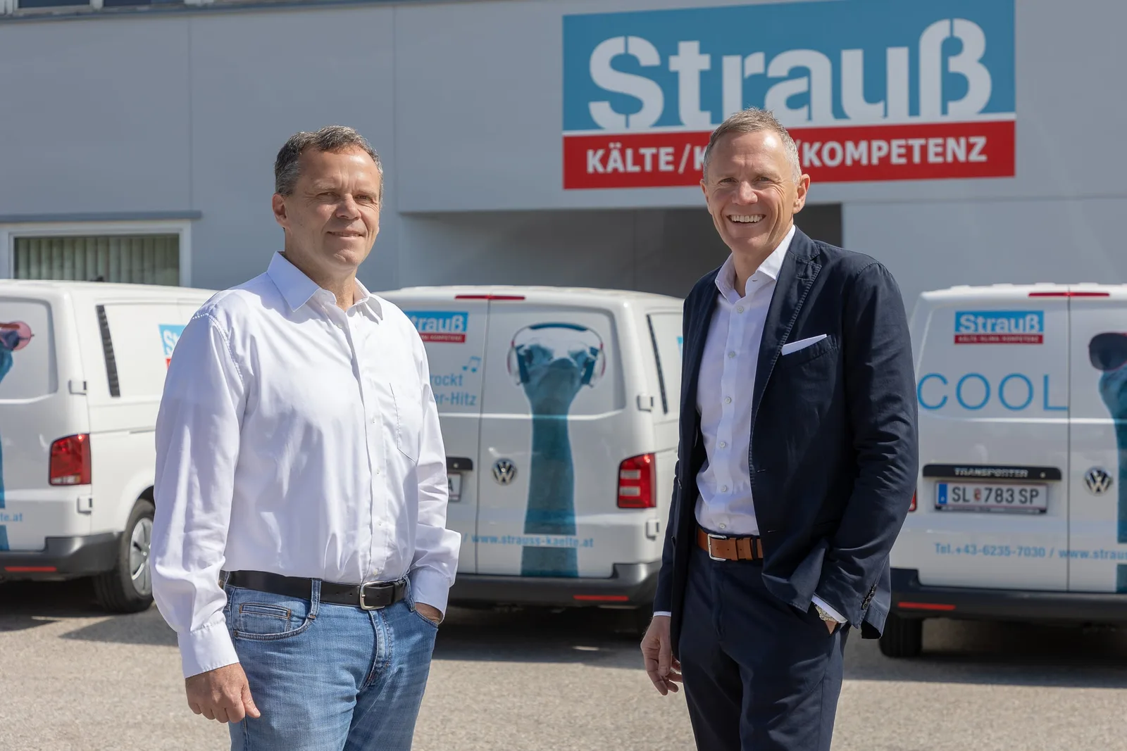 Die Geschäftsführer Peter und Rudolf Strauß vor dem Firmengebäude und den Firmenwagen